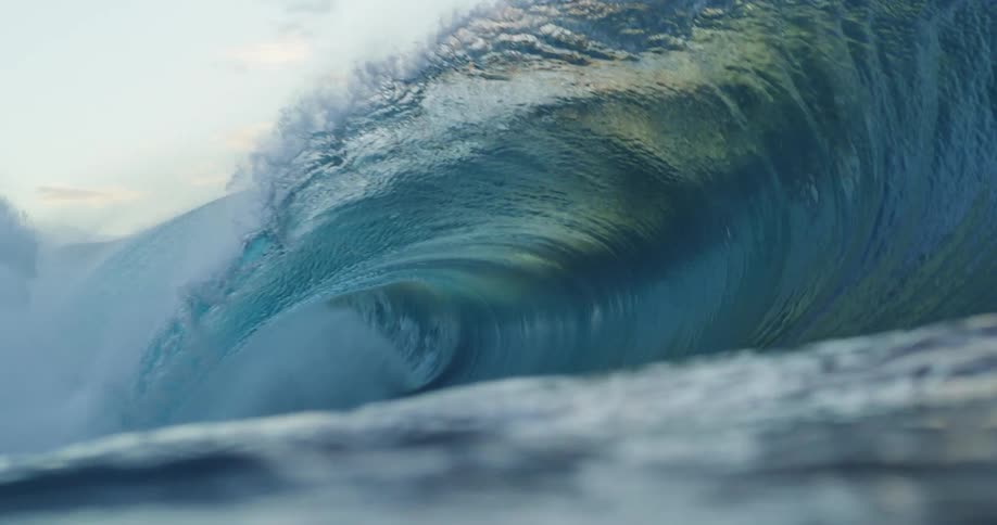 A massive and powerful ocean wave curls over and crashes down