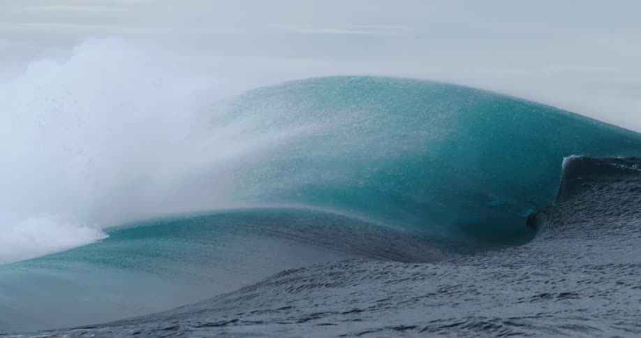 Ocean waves swell and collapse under an overcast sky