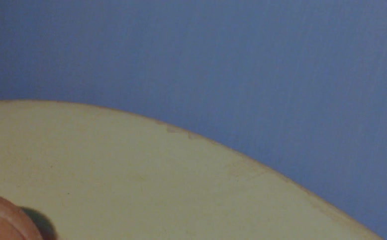 A finger of a person holding an object and engaged in manufacturing
