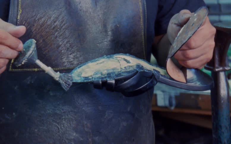 Man glues sole onto shoe in workshop