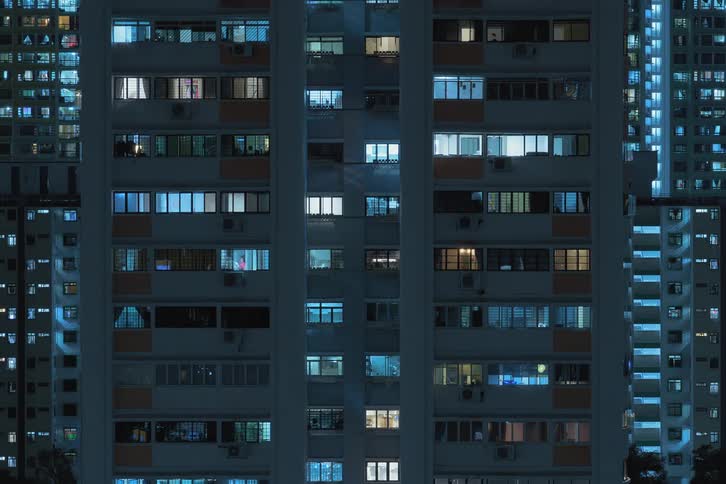 Lights are turning on in a residential apartment in an urban city