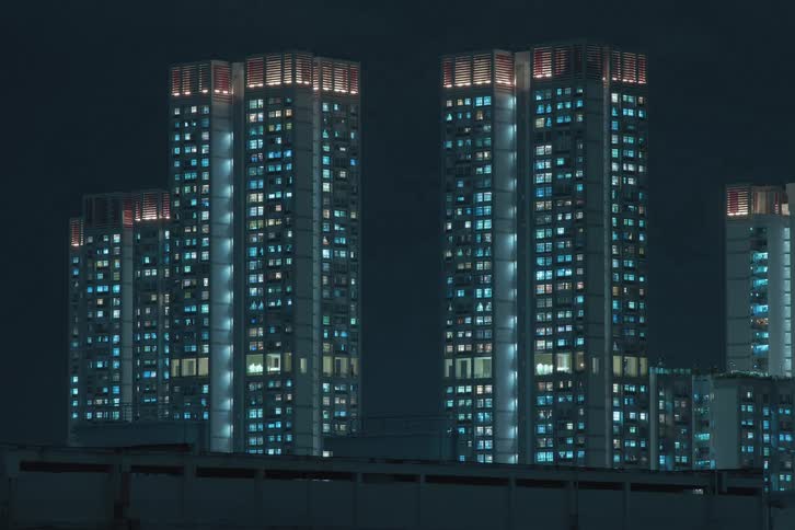 Apartments lights of skyscrapers in a city turn on