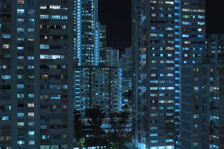Window lights turning on in multiple skyscrapers during the night