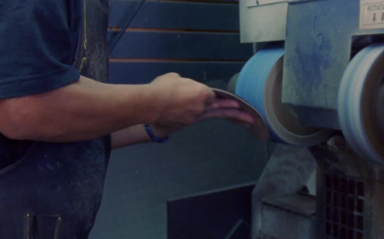 Man sanding a shoe sole on a machine