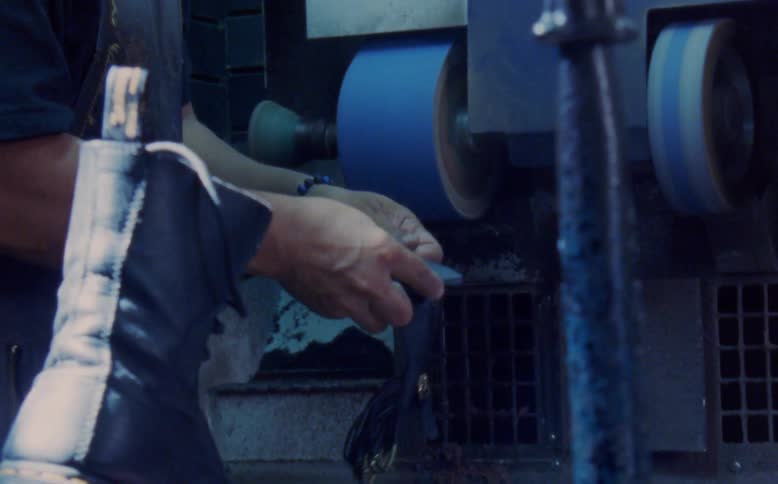Man in a workshop making female shoe with a machine