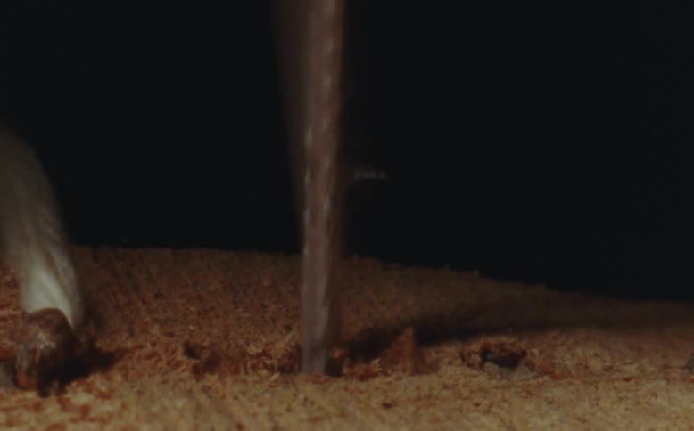A tool piercing wood with a white line
