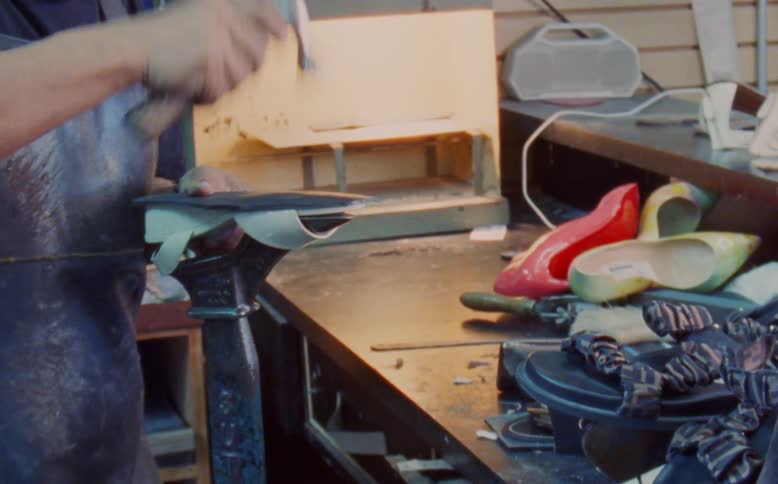Man using a hammer on a shoe in a workshop