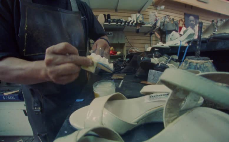 Hands of a carpenter crafting a womens highheeled shoe