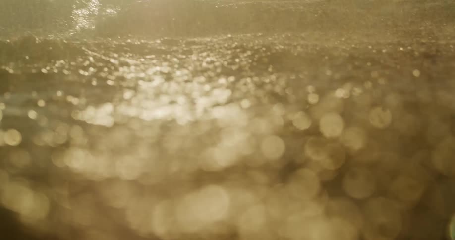 View from inside the sea with rain sunlight reflection and waves
