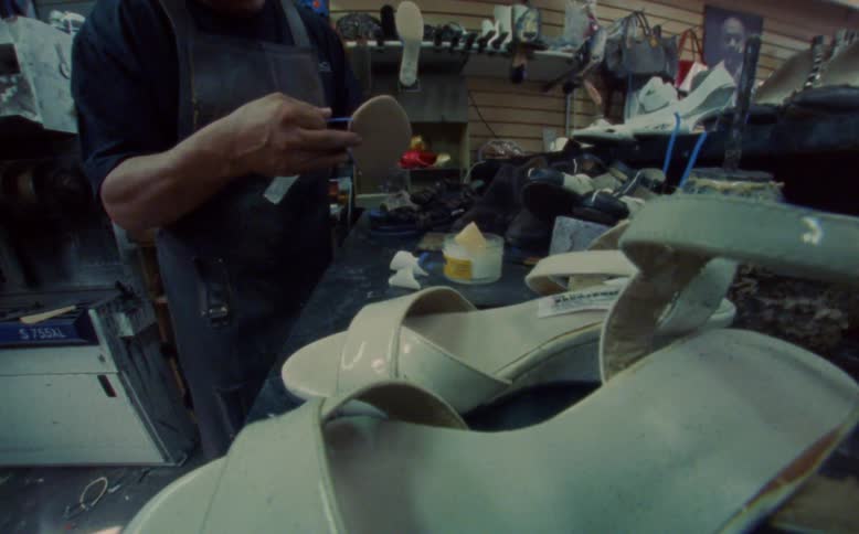 Man performing manufacturing work on a womans high heel