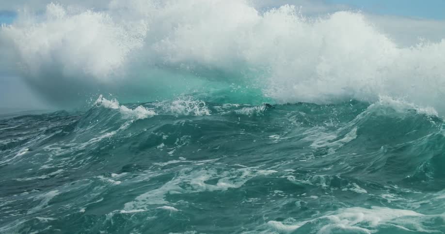 Powerful green ocean waves crash in the coast