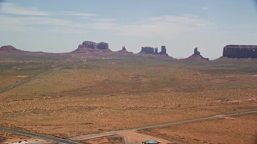  aerial footage of cars moving on Highway 163 in Monument Valley Arizona with buttes in the background
