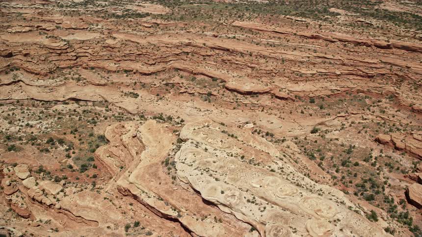 A mesmerizing aerial view of Utah's Cedar Mesa showcasing stunning canyons and mesa cliffs as the drone glides through narrow gorges and rugged terrain in the badlands during daytime