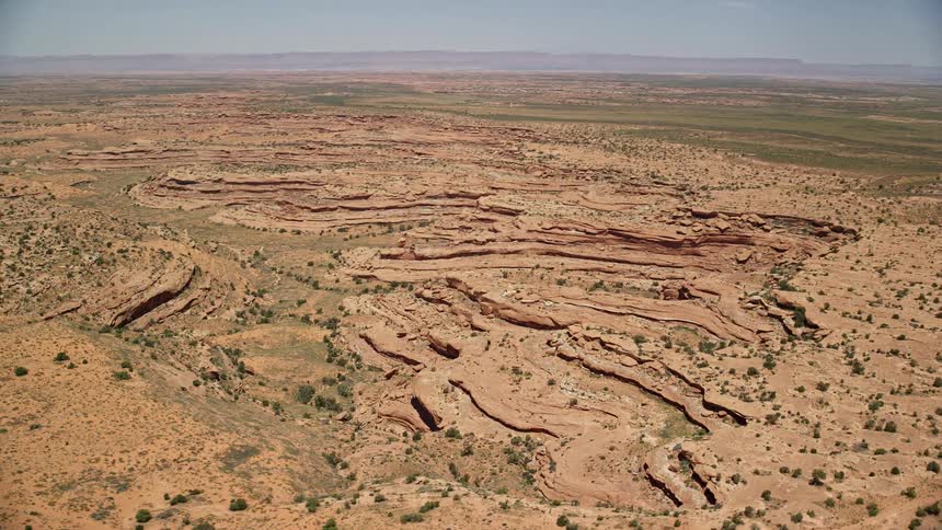 an aerial view of desert rock formations in the wild landscape of Navajo Nation Reservation Utah and Arizona