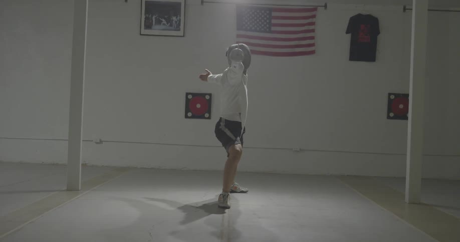 Person practices fencing in a small room