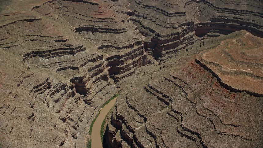 Aerial footage of the San Juan River flowing through a deep desert canyon in the Navajo Nation Reservation showcasing the natural beauty of the southwest United States