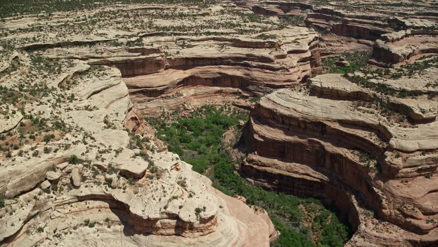 anaerial footage showcasing the magnificent circling of Grand Gulch canyon cliffs in the arid and sunny Grand Gulch Primitive Area Utah