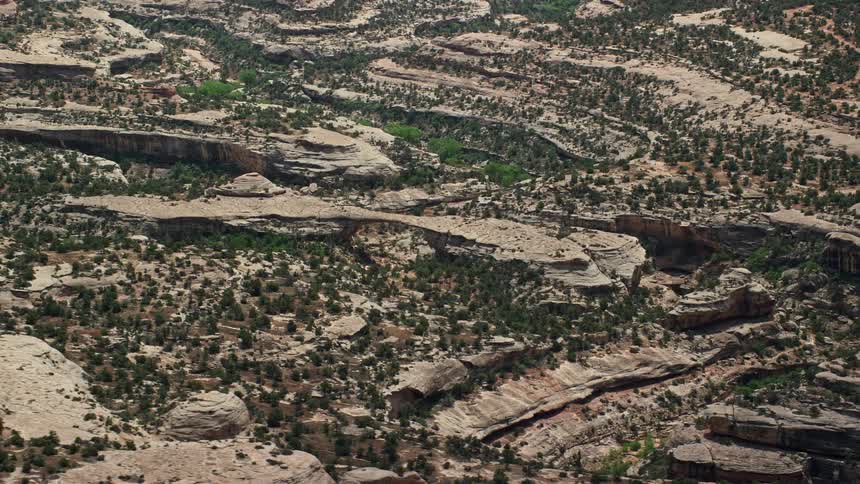 A mesmerizing aerial view of Owachomo Bridge a natural rock bridge surrounded by canyons and mountains in Natural Bridges National Monument Utah
