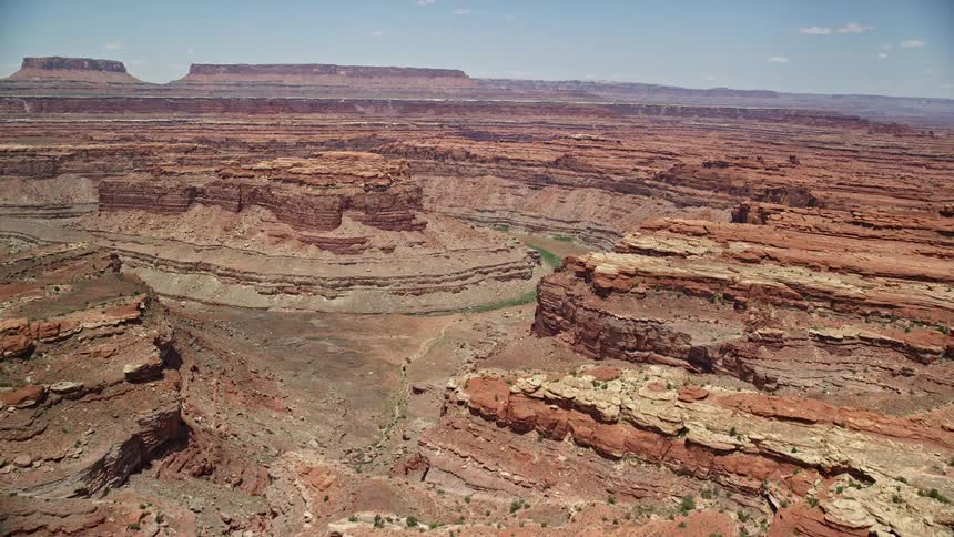 Aerial footage of the Colorado River meandering through Meander Canyon in Canyonlands National Park Utah showcasing the breathtaking curves of the canyon in the arid badlands landscape