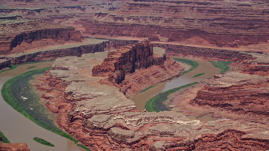 Aerial footage of the Colorado River and a butte in Goose Neck of Meander Canyon Canyonlands National Park capturing the arid landscape and natural beauty of the southwest United States