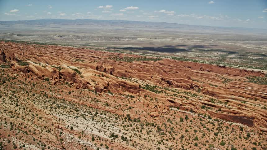 Aerial footage captures the stunning rock formations of Devil's Garden in Arches National Park Utah as the camera flies over the rock fins