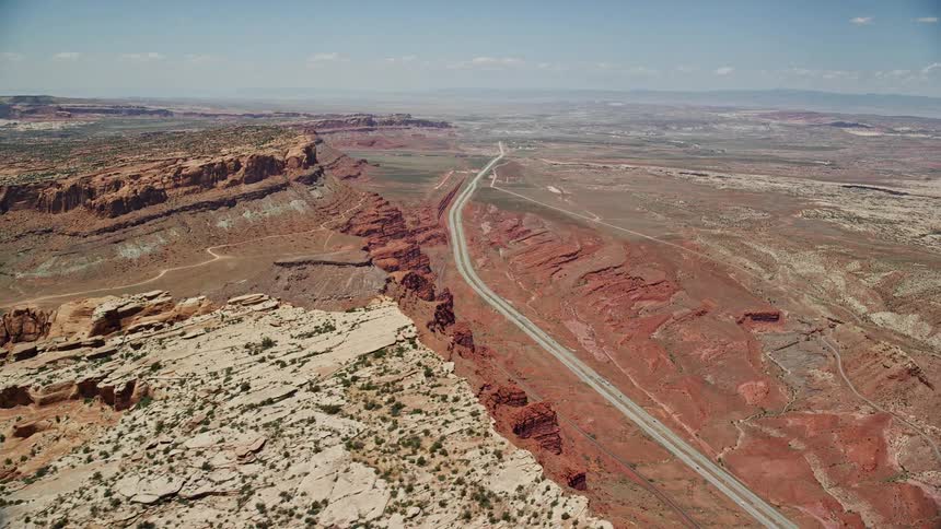 Aerial footage showcasing a desert valley and scenic highway with vehicles moving through Moab Utah