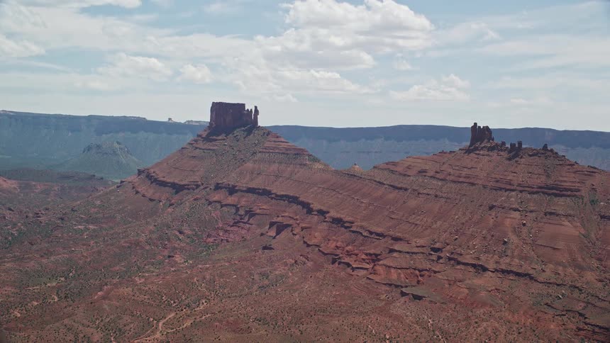A stunning aerial view of two towering desert buttes in Moab Utah showcasing the arid landscape and natural beauty of the Southwest United States during a sunny summer day