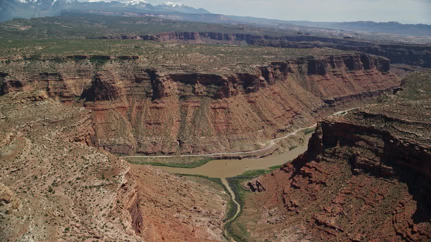 Aerialvideo showcasing the Colorado River and canyon road in Arches National Park Utah during a sunny day