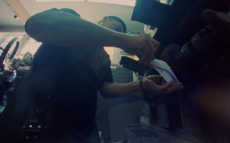 A man inside his work shop filling down a ladies shoe
