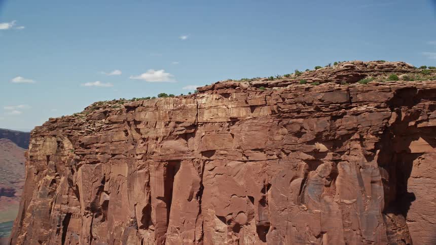 Aerial footage of steep butte cliffs in Moab Utah captured during a sunny day in the Southwest United States