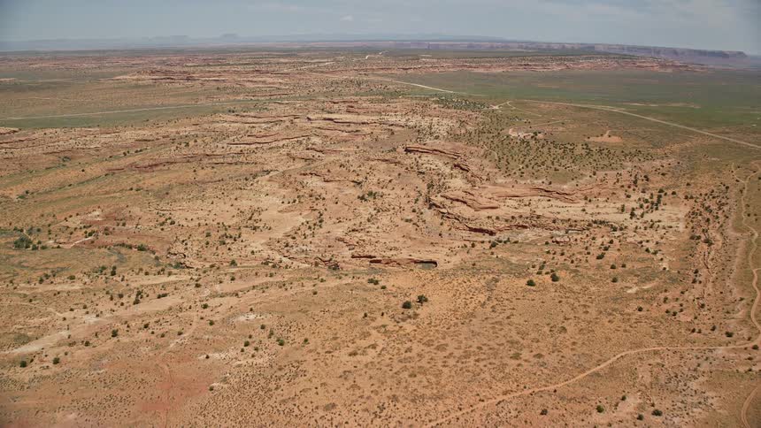 an aerial view of the open desert valley in Monument Valley Utah and Arizona showcasing the stunning natural landscape mountains and canyons during the daytime