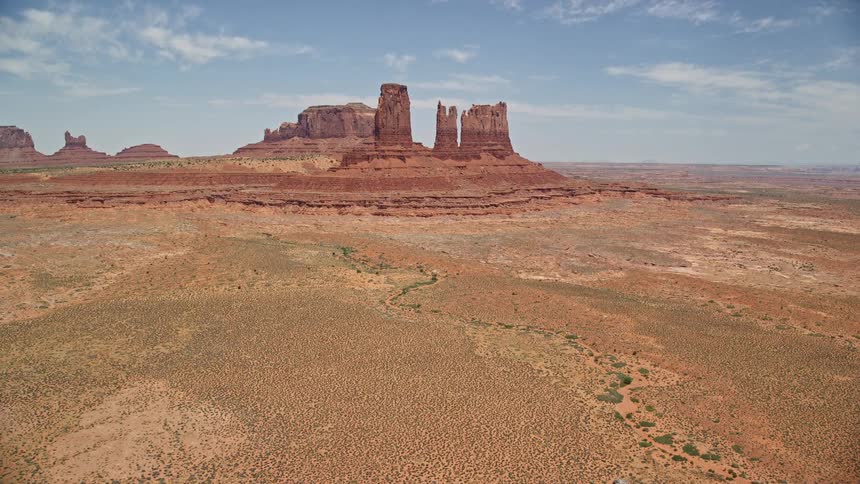 Flying towards jagged desert buttes in Monument Valley Utah and Arizona capturing the stunning natural rock formations and landscape on a sunny day