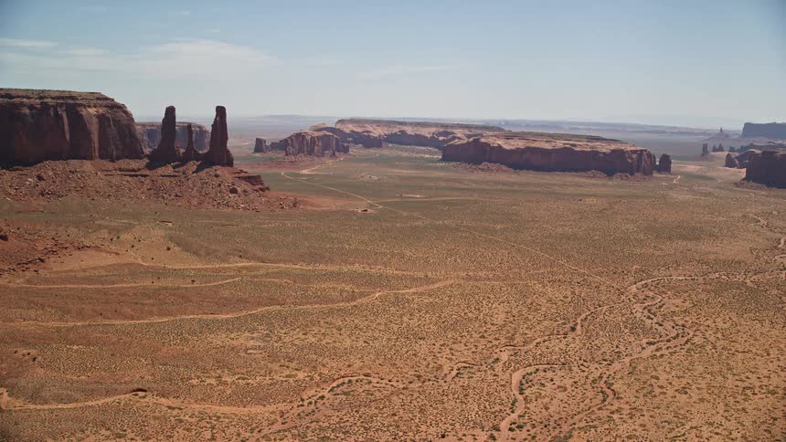 Aerial flyby of buttes and mesas in Monument Valley Utah revealing Elephant Butte on a sunny day