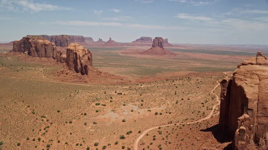 Aerial footage of passing desert buttes and mesas in Monument Valley Utah Arizona approaching famous landmarks in the wild west landscape