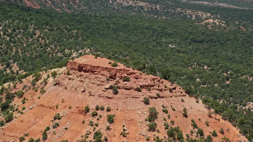 Aerial footage of circling the top of a rocky mountain peak in the Manti-La Sal National Forest showing the arid and sunny landscape of Utah's southwest region