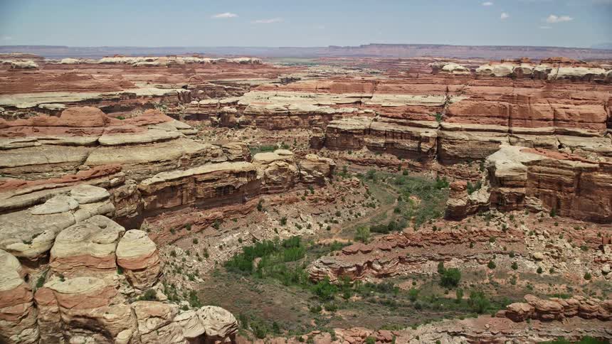 Aerial tilt and fly over stunning rock formations and desert canyons in the famous Canyonlands National Park Utah during daylight hours