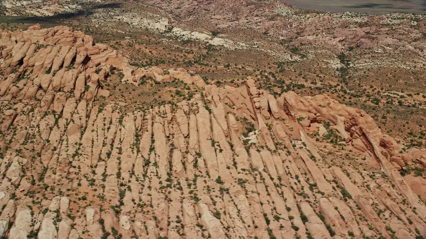 Aerial footage of flying by desert rock formations and stunning views at Arches National Park Utah showcasing the natural beauty of the Southwest United States during summertime