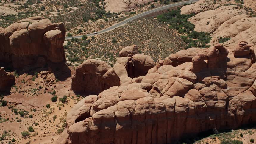an aerial view of the iconic Double Arch and Elephant Butte at Arches National Park Utah showcasing the stunning rock formations and arid landscape in the southwest United States during a sunny summer day