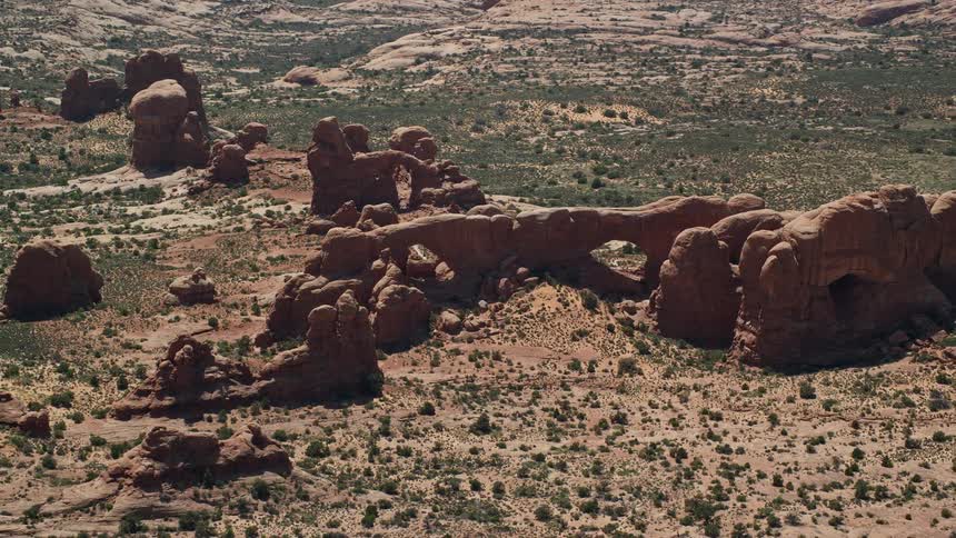  aerial footage showcasing the iconic North Window South Window and Turret Arch rock formations in Arches National Park Utah during a sunny summer day