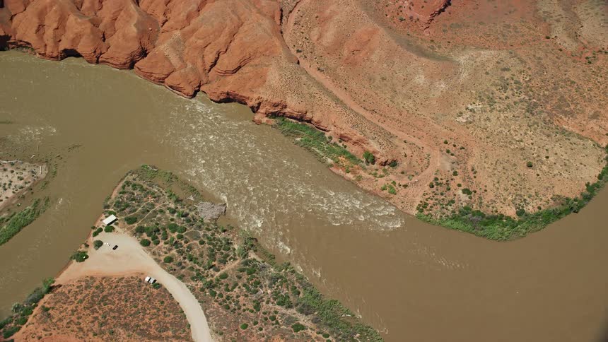 A stunning aerial view of rapids on the Colorado River in Moab Utah with clear blue skies and desert surroundings