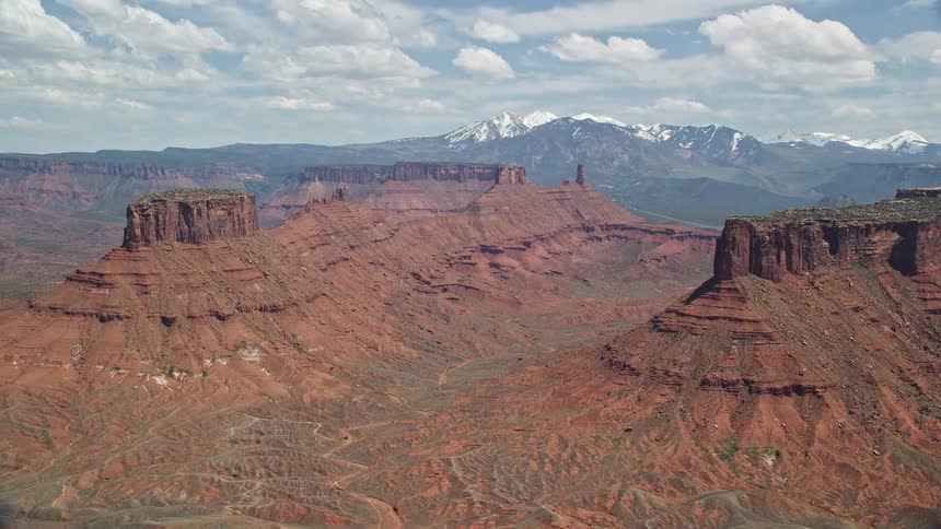 an aerial view of buttes and mesas in the arid and sunny landscape of Moab Utah showcasing the natural beauty of the desert during a summer day