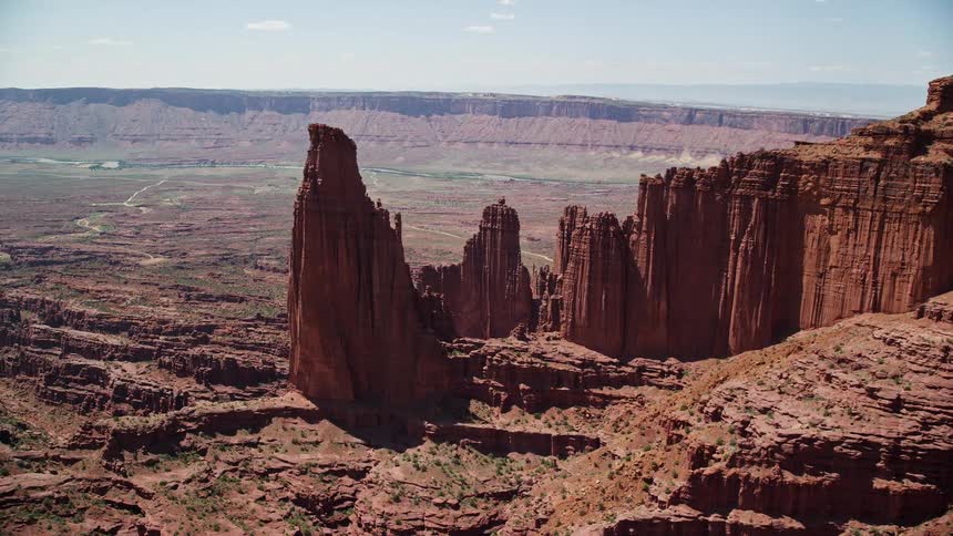 Approaching Fisher Towers and nearby rock formations at Fisher Towers Utah during a sunny day in the desert landscape