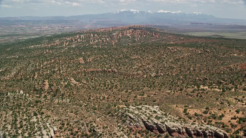 Aerial flyover of Devil's Garden in Arches National Park Utah showcasing the stunning red rock canyon walls and desert landscape during a sunny day in the summer