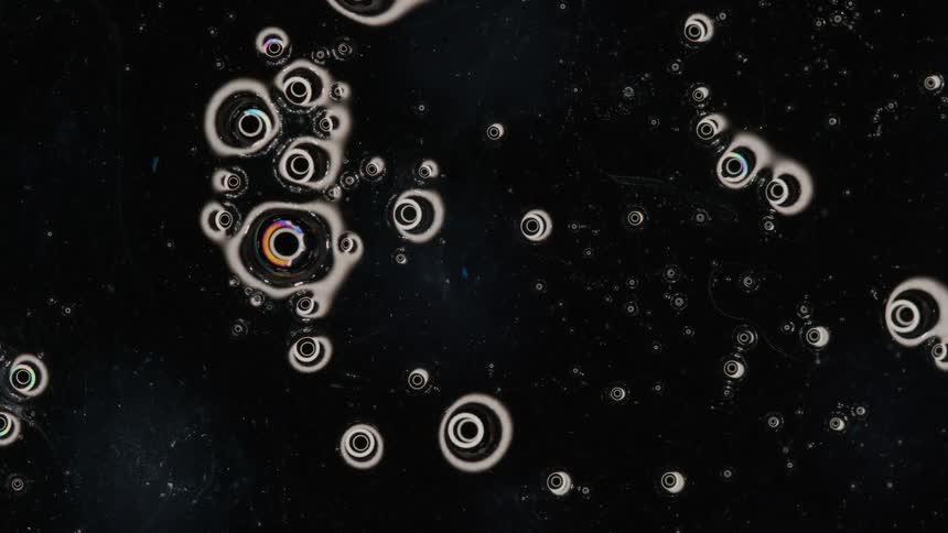 White ink rings floating over a black background