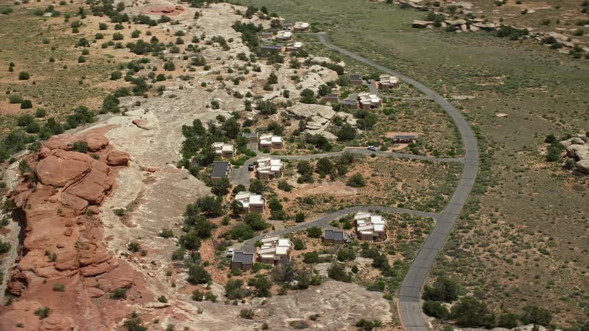  aerial footage of homes orbiting Residence Road in the rural area of Canyonlands National Park Utah showcasing the rustic arid landscape and famous landmarks of the southwest United States during the daytime