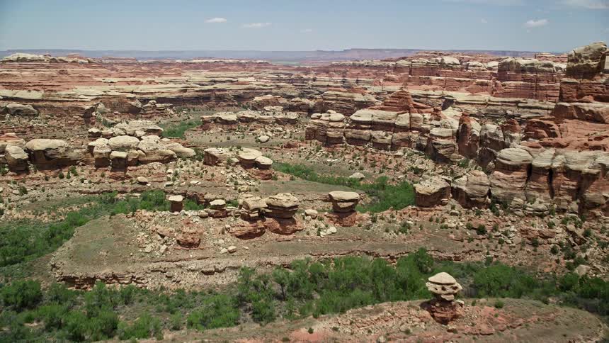  aerial footage of flying over boulders rock formations and canyons in Canyonlands National Park Utah showcasing the stunning natural beauty of the arid desert landscape