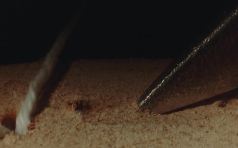 Closeup of a sewing needle threading through material in a manufacturing process