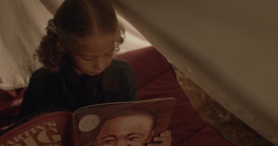 A child reads a large paperback book