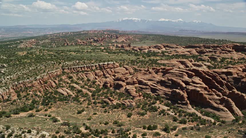  aerial footage showcasing rock formations desert vegetation and Eagle Park in Arches National Park Utah during a sunny summer day