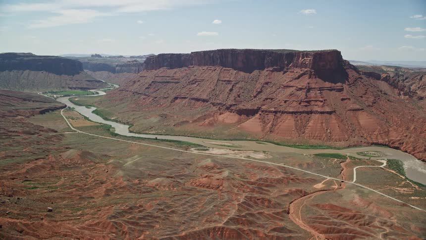 Approach the Colorado River and Dry Mesa in Moab Utah during a sunny day in summer